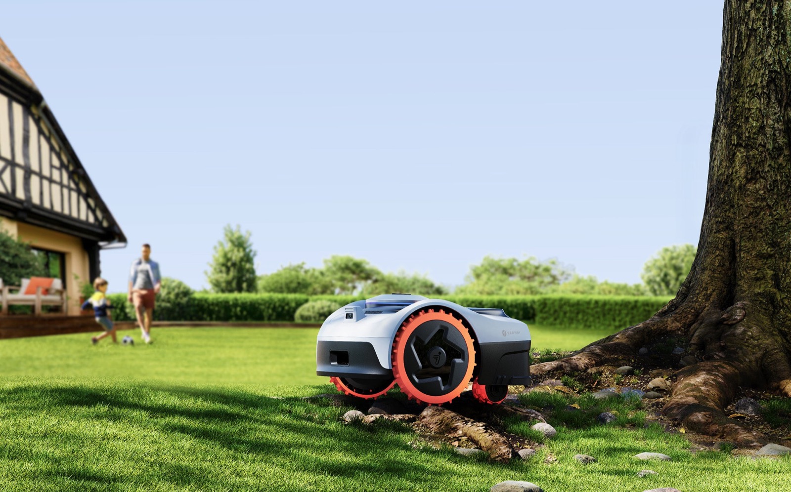 Segway Navimow i2 AWD klipper gresset ved et tre mens en familie er i bakgrunnen